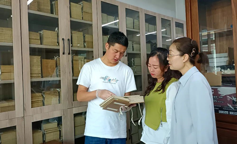 張旻（左）在大通縣圖書館了解、翻閱清代印制的經(jīng)史子集典籍