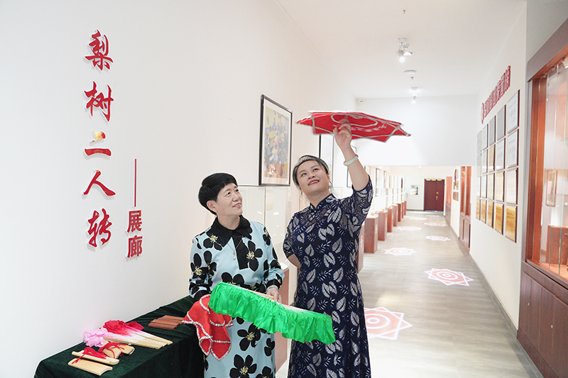2023年6月29日，在吉林省梨樹(shù)縣地方戲曲劇團(tuán)梨樹(shù)二人轉(zhuǎn)展廊，團(tuán)長(zhǎng)趙丹丹（右一）為作家龔保華講解二人轉(zhuǎn)技巧。