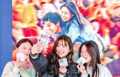 2月18日，觀眾在貴州省黔西市一家影院的電影海報前留影。 新華社發(fā)