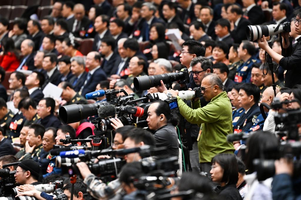 3月8日，十四屆全國人大二次會議在北京人民大會堂舉行第二次全體會議。這是記者在會議現(xiàn)場采訪。新華社記者 牟宇 攝