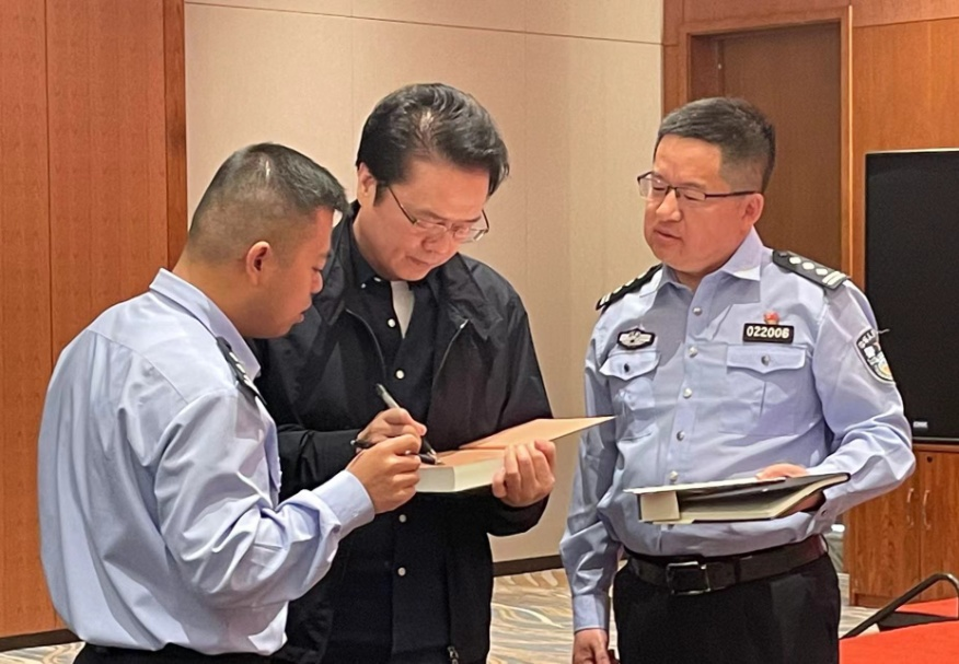 活動期間，陳彥（圖中）在給警營作家簽名。