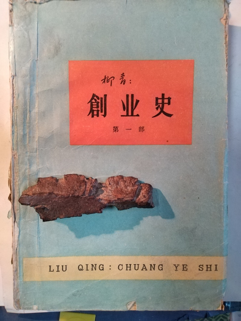 長篇小說《創(chuàng)業(yè)史》（第一部）書影與柳青曾收藏的彈片。 （文金 攝）