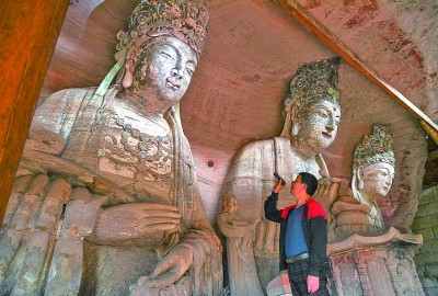 義務文保員在對重慶市大足區(qū)寶頂鎮(zhèn)香山社區(qū)的佛祖巖摩崖造像進行巡查。新華社記者 王全超攝