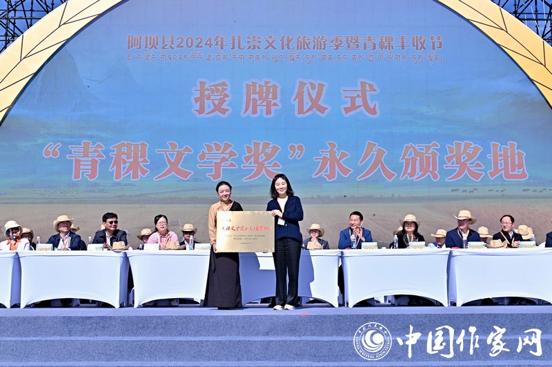 陳亞軍主編代表《民族文學》向阿壩縣授牌，紅梅部長接牌。
