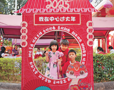 老撾民眾在“歡樂春節(jié)”廟會現(xiàn)場設(shè)立的新春祈福打卡點(diǎn)拍照。  坎帕頌攝