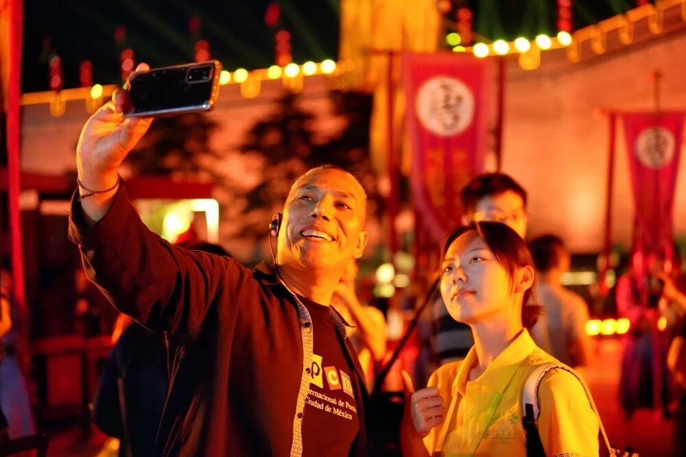 參加2025國際青春詩會(huì)的拉美詩人和中國詩人在西安永寧門觀看歡迎儀式。圖為墨西哥詩人馬努艾爾·夸烏特勒在歡迎儀式后與志愿者合影